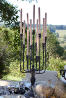 Antiqued iron candelabra centerpiece holding taper candles